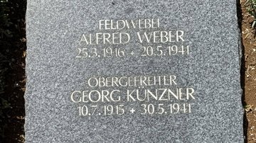 Eine gesäuberte Grabplatte mit Namen und Lebensdaten zweier Gefallener