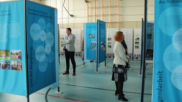 Ein Mann und eine Frau schauen sich Ausstellungstafeln an.