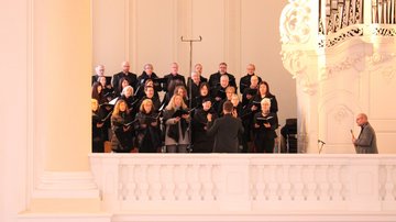 Ein Chor singt auf der Empore einer Kirche.